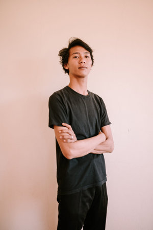 A Southeast Asian man crossing his arms, showcasing confidence and assertiveness, perfect for...