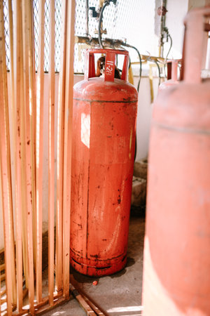 A large orange gas cylinder standing upright, emphasizing safety and utility. Perfect for themes of industrial equipment, energy, and household essentials.の写真素材