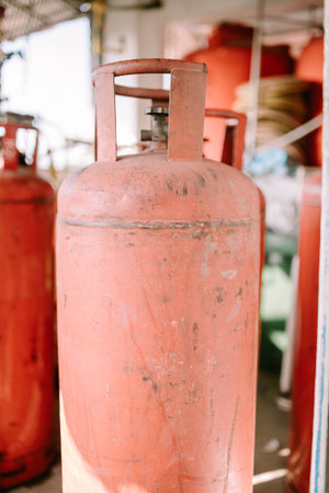 A large orange gas cylinder standing upright, emphasizing safety and utility. Perfect for themes of industrial equipment, energy, and household essentials.の写真素材