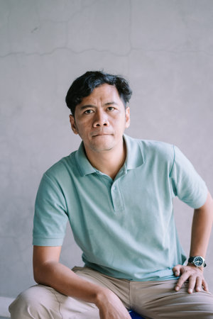 A Southeast Asian man with a sweet expression, looking forward, capturing a moment of calm and charm, perfect for portrait, lifestyle, and emotional projectsの写真素材