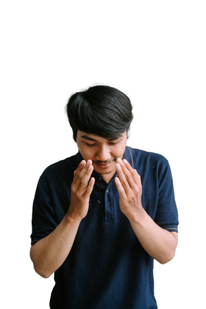 A Southeast Asian man with hands clasped together, capturing a moment of calm and devotion.の写真素材