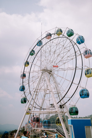 A Ferris wheel with a backdrop of slightly cloudy skies, creating a moody and atmospheric sceneの写真素材