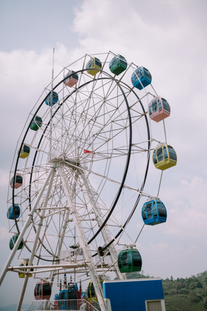 A Ferris wheel with a backdrop of slightly cloudy skies, creating a moody and atmospheric sceneの写真素材
