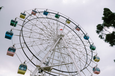 A Ferris wheel with a backdrop of slightly cloudy skies, creating a moody and atmospheric sceneの写真素材