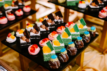 Hundreds of colorful, cute-shaped sweet pastries displayed on a table, ready to be served to guests. So yummy.の写真素材