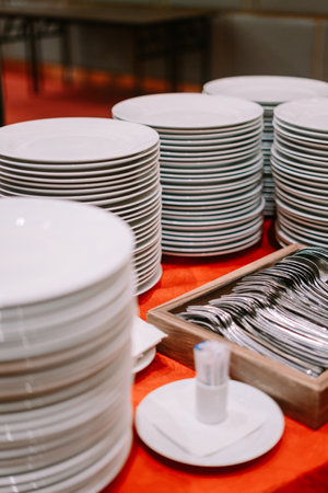 A stack of clean plates and spoons neatly arranged on a buffet table so niceの写真素材