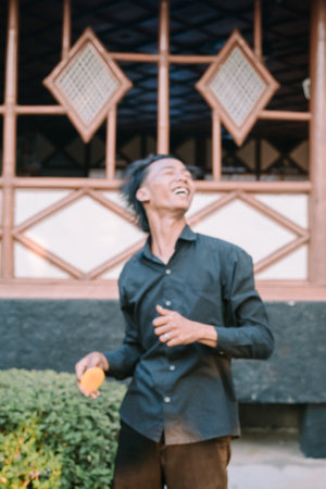 Southeast Asian man dancing happily, expressing joy and enthusiasm through lively movementsの写真素材
