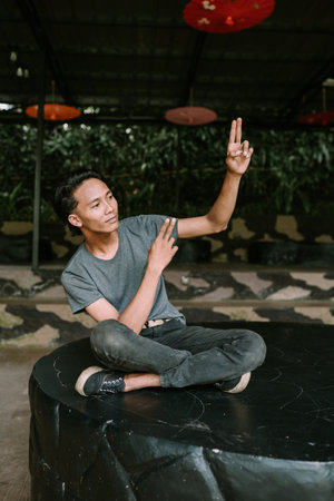 A Southeast Asian man dancing joyfully, mid-move with expressive body language and a cheerful expression.の写真素材