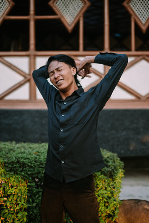 A Southeast Asian man is stretching his back while pushing his hips forward.の写真素材