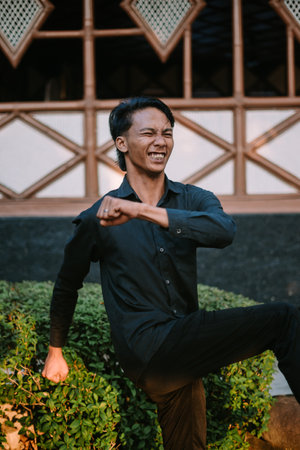 A Southeast Asian man is stretching his back while pushing his hips forward.の写真素材