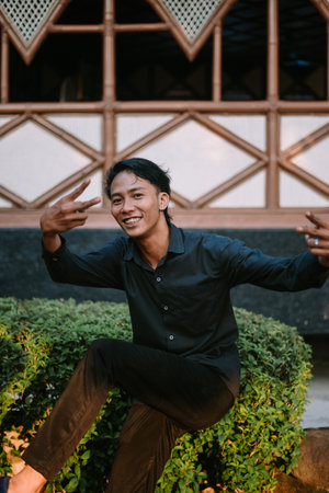 A Southeast Asian man striking a silly pose with a playful expression so funnyの写真素材