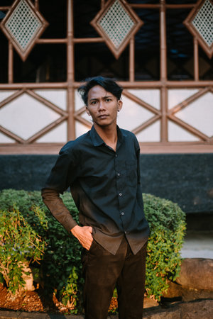 A Southeast Asian man wearing a black shirt, posing with his hands in his pockets so niceの写真素材