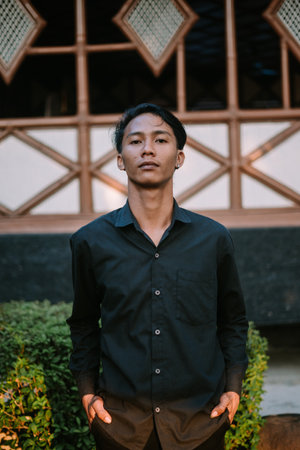 A Southeast Asian man wearing a black shirt poses stylishly in front of the camera.の写真素材