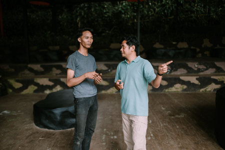 Two men are standing and conversing in an outdoor setting.の写真素材