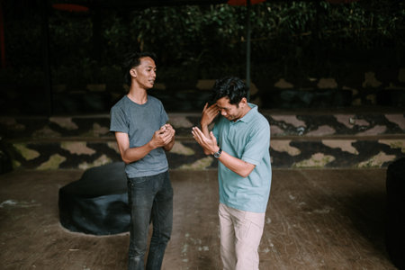 Two men standing in a room, engaged in a conversation.の写真素材