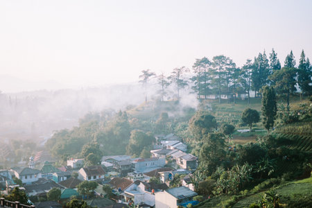 Thick fog and smoke covering a mountainous region, creating a mysterious and moody atmosphere. Ideal for themes of nature, weather, and environmental impact.の写真素材