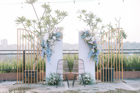 Beautiful outdoor wedding backdrop decorated with flowers and elegant fabric, creating a romantic and natural setting for the ceremonyの写真素材