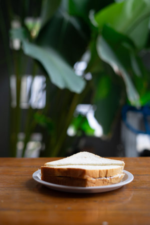 A sandwich sits on a wooden table, ready to be enjoyed
