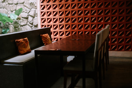 Chic cafe with geometric terracotta wall, pendant lamps, and cozy seating.の写真素材