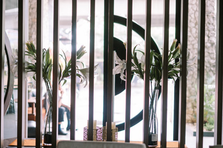 Elegant white lilies in vases with decorative candles.の写真素材