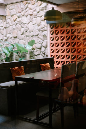 Intimate cafe corner with a table, bench seating, and a decorative wall.