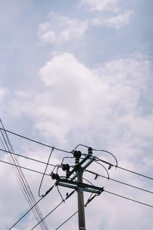 Electricity pylon and power lines silhouetted against a cloudy sky.の写真素材