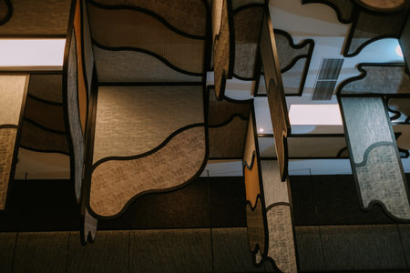 Unique and stylish acoustic panels suspended from the ceiling, designed for noise reduction and creating a modern interior aesthetic. The decorative panels add texture and an artistic touch to the architecture.の写真素材