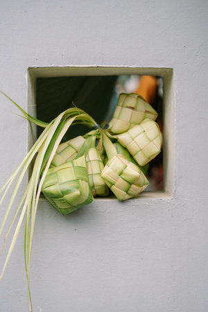 Ketupat is a traditional rice cake popular in Southeast Asia, especially during festive seasons like Eid al-Fitr. The rice is wrapped in woven palm leaves and boiled.の写真素材