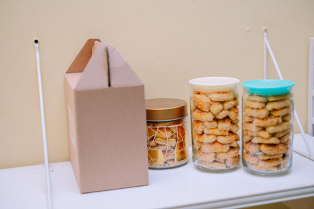 A delightful arrangement of pineapple tarts in jars and packaging, ready for festive celebrations. These golden, homemade cookies offer a tasty and crunchy snack experience, perfect for sharing during special occasions.の写真素材