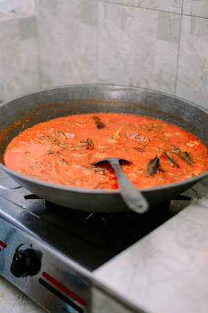 Close-up of simmering seafood curry in a big cooking pot. A flavorful dish prepared with culinary expertise. Represents authentic cuisine and homemade recipes, highlighting the essence of traditional cooking. Perfect for illustrating cultural foods and dining experiences.の写真素材
