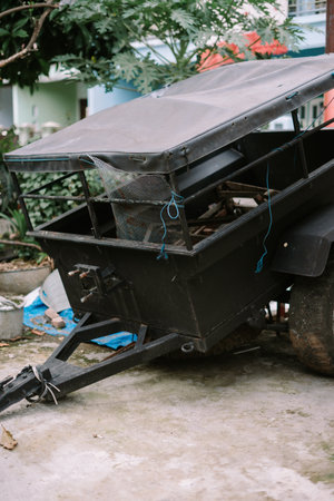 An unkempt utility trailer sits in an outdoor environment. The trailer shows signs of usage. Its weathered appearance speaks to its functionality. This image captures the essence of rural or domestic activity.の写真素材