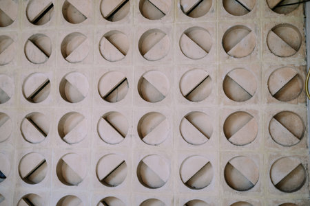 Detailed architectural concrete wall. Geometric pattern featuring circles divided by diagonal lines creates a textured and modern surface.の写真素材