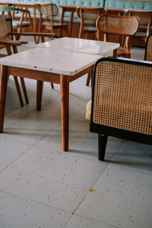 Close-up of vintage dining area featuring wood furniture and terrazzo table for cozy interior design...