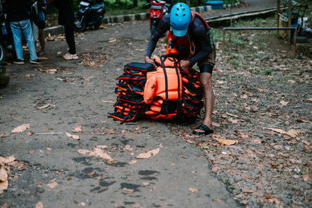 Stack of orange life vests prepared by tour guide for a water adventure activity such as rafting