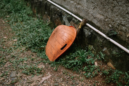 A traditional conical hat rests beside a weathered wall, showcasing rustic charm and rural simplicity.の写真素材