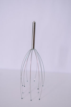 Close up of a handheld scalp massager on a white surface for stress reliefの写真素材