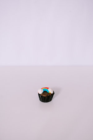 A delightful cupcake decorated with a vibrant rainbow, standing out against a clean background, tasty single treatの写真素材