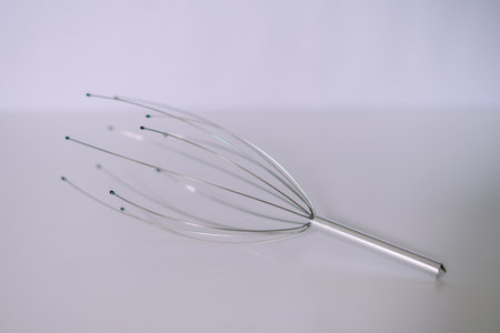 Head massager tool on a plain background. Concept for relaxation and well beingの写真素材