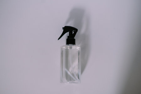 A simple clear spray bottle with a black trigger, sitting against a white background, perfect for showcasing cleaning or cosmetic products.の写真素材