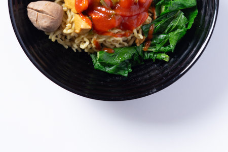 A delicious noodle bowl featuring savory meatballs, fresh vegetables, and a tangy sauce, an inviting dishの写真素材