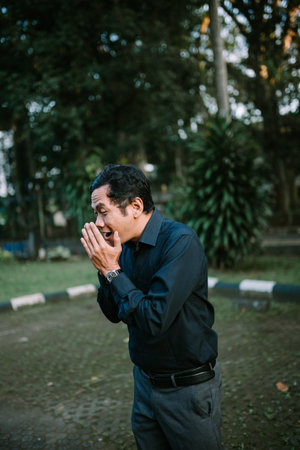 A middle-aged man expresses surprise outdoors. His eyes are wide with amazement. He looks joyful and elegantの写真素材