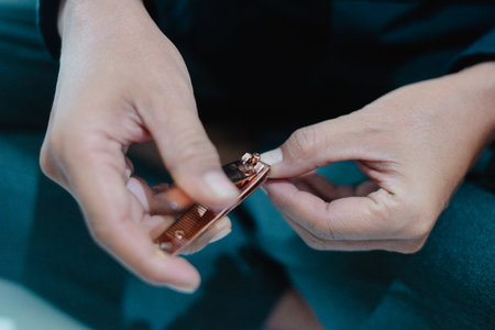 Close-up shot of a person using a nail clipper to trim their fingernails, focusing on hand and the tools, showcasing the process of personal grooming. Focusing on the small details and care of theの写真素材