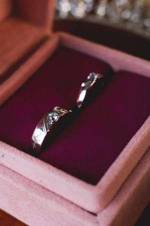 Close-up shot of two exquisite diamond rings nestled within a soft velvet box. The rings symbolize...