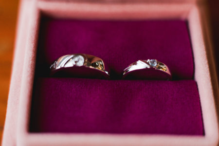 Two exquisite wedding rings rest serenely within a velvet box, symbolizing a promise of love and...