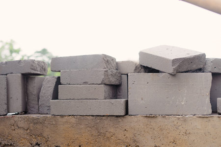 A close-up image showing a pile of concrete blocks. The blocks are stacked in a haphazard manner...