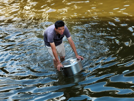 October 21; 2011 Rongsit, Phathumtrani, Thailand: man taking food for the family, during the worst flooding disasterのeditorial素材