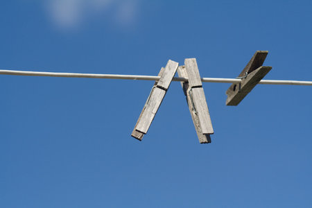 Simple composition showing clothes-pegs on a line. Deep blue background.の写真素材