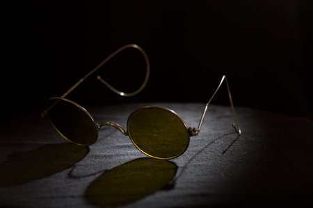 A pair of old worn sunglasses with background light.の写真素材