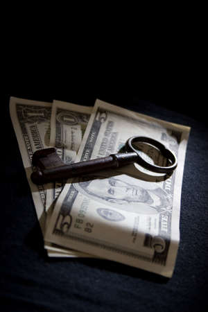 An old key on US dollar notes. positioned in a spotlight.の写真素材