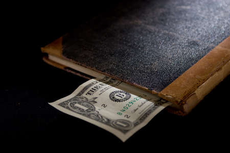 An old accounting book with a dollar note sticking out.の写真素材